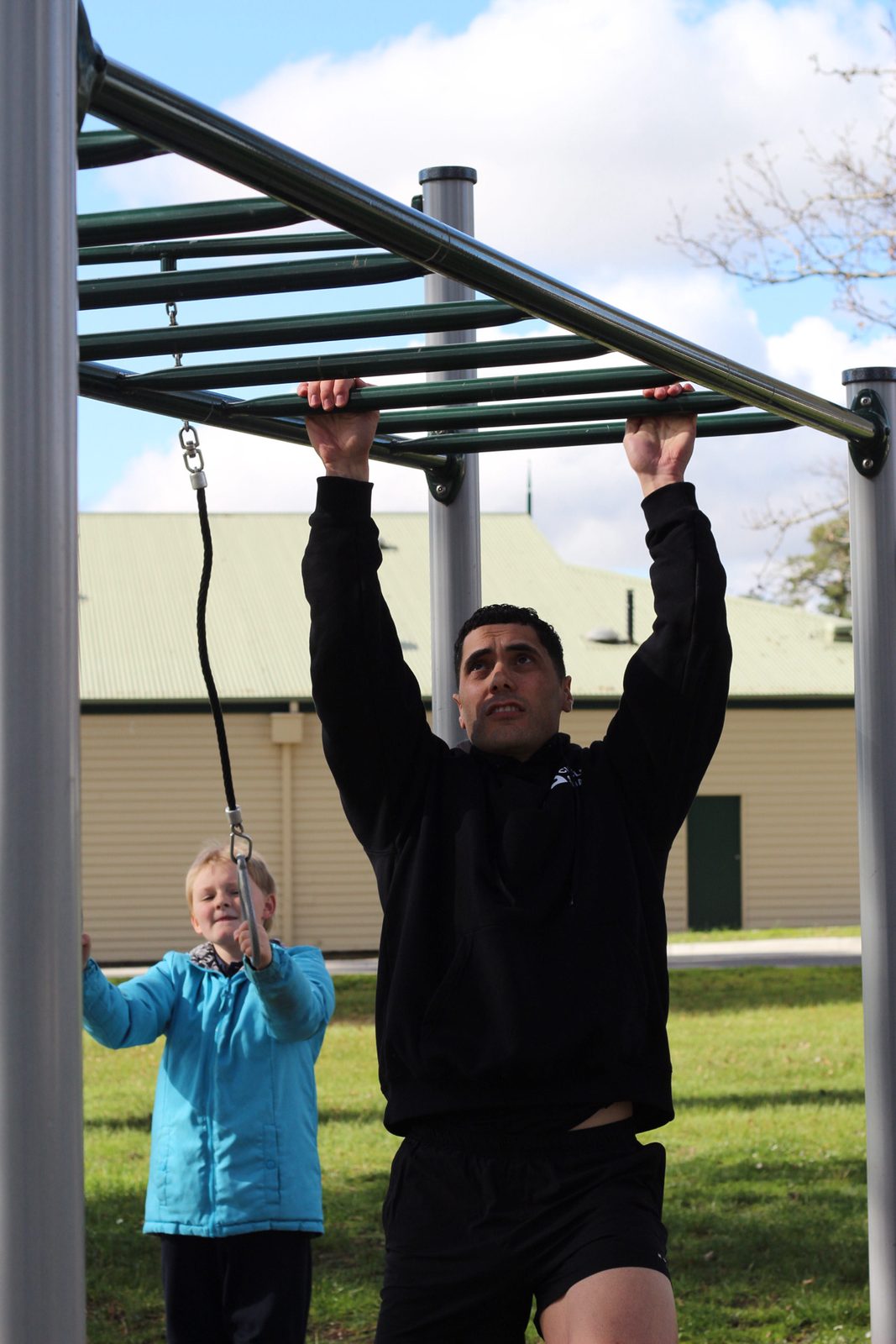 Demonstrating a pull-up on the outdoor bars