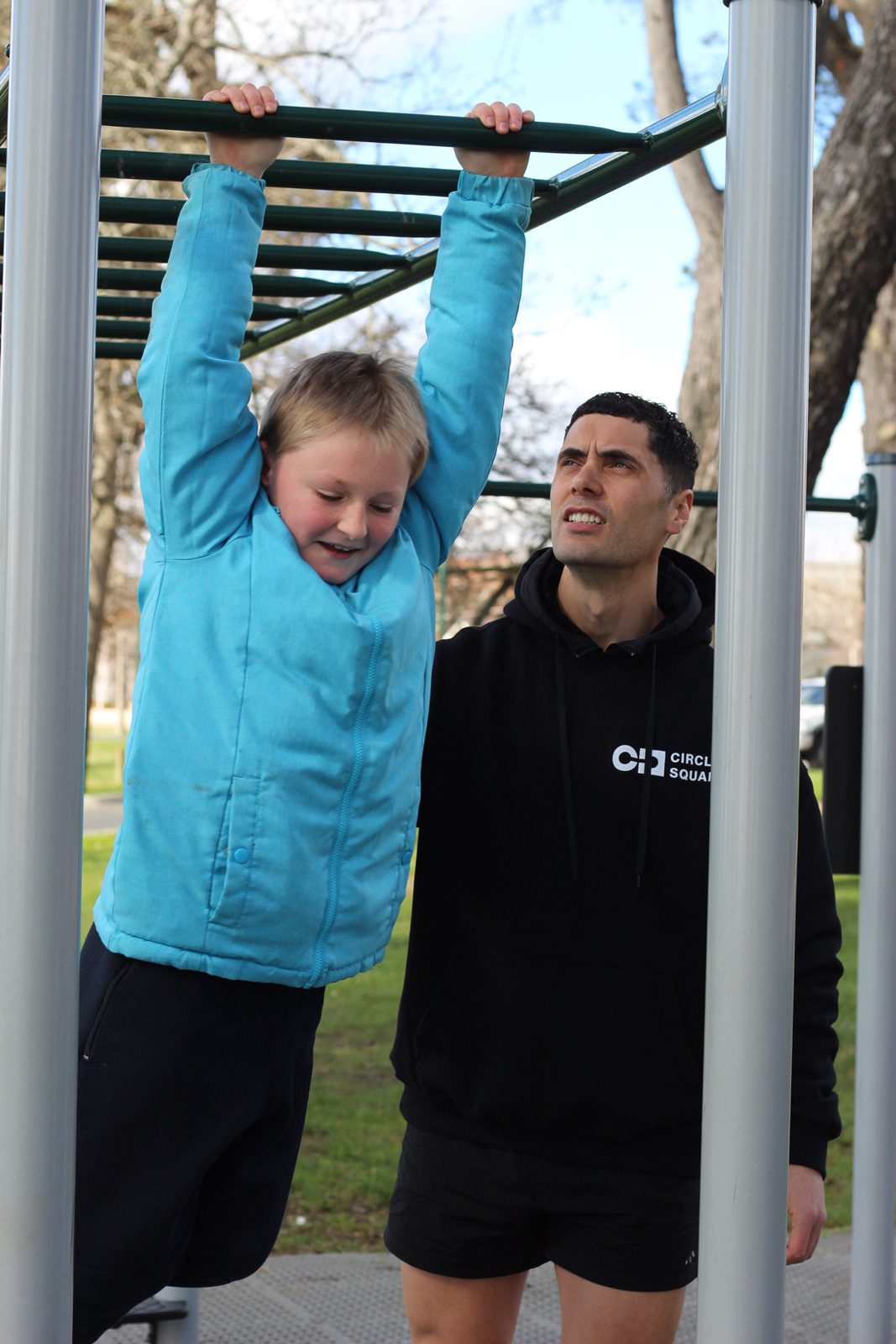 Spotting a participant on the monkey bars at a local park