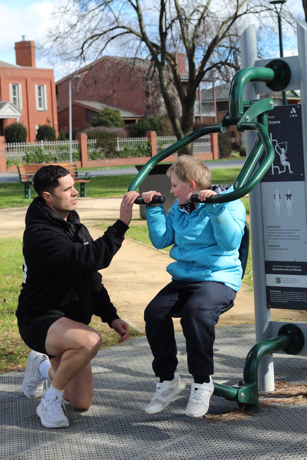 Coaching a participant through an outdoor gym machine