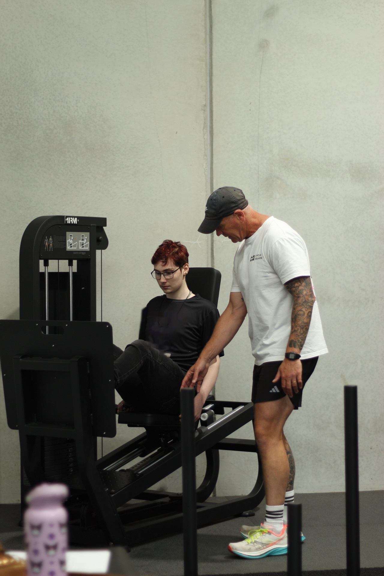 A trainer assisting a participant with correct form